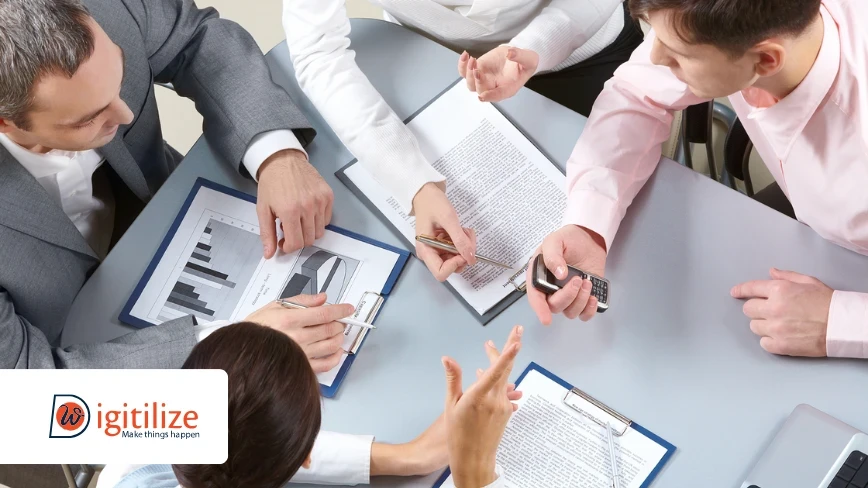 Business team discussing documents and charts – Digitilize branding.